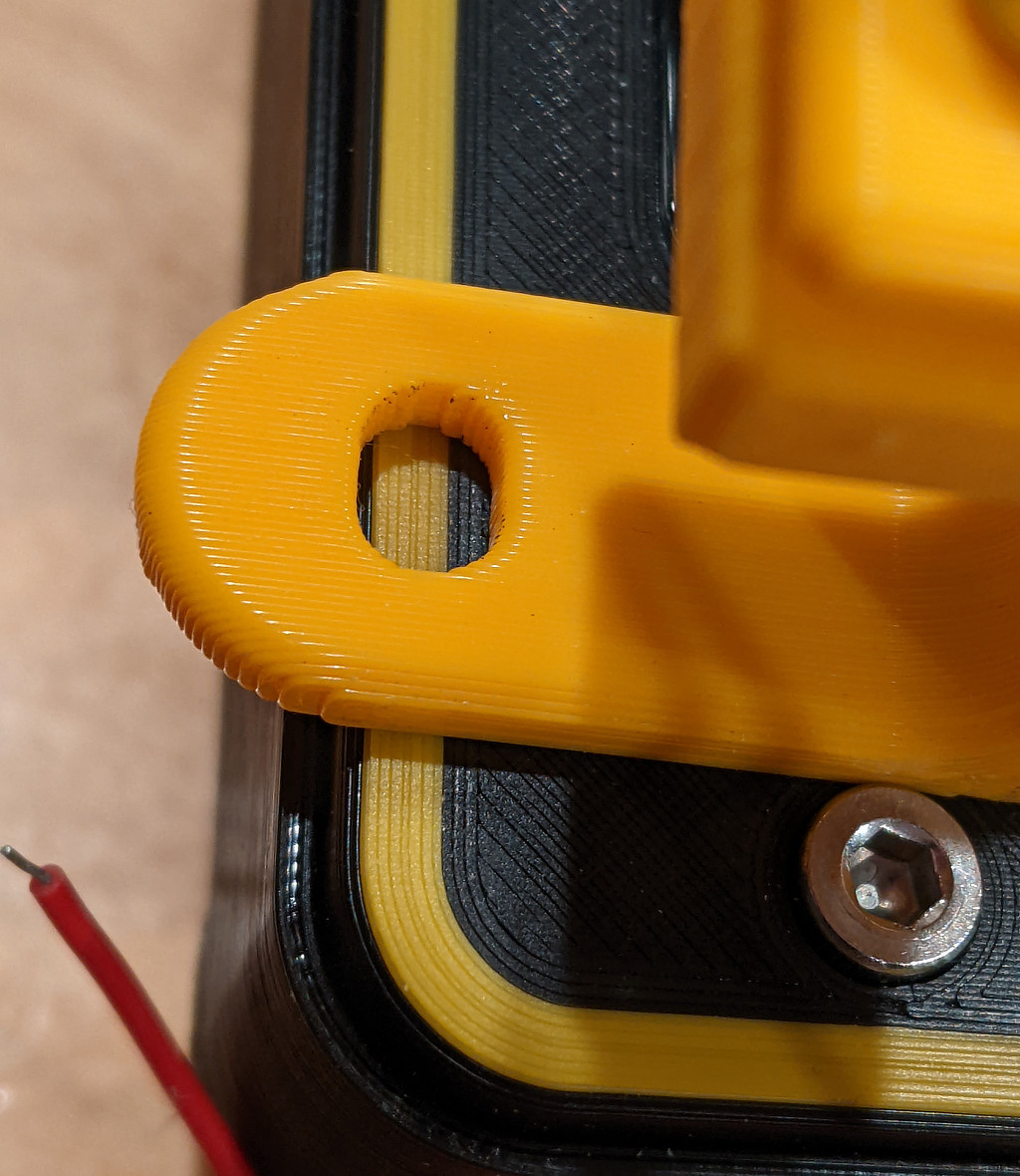 Black box with a small yellow inlayed border, compared to another part printed entirely with the same filament. The border's color is less intense, and darker